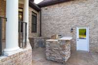 Grill and entertain with ease at the built-in outdoor kitchen, featuring a stone bar and stainless appliances—perfect for summer cookouts!