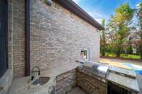 An outdoor stone fireplace keeps things cozy year-round, while the built-in grill and expansive stamped concrete patio make entertaining effortless.