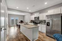 Flowing kitchen with island bar and storage.