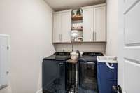 1st floor laundry with added cabinets & shelves.  New tile floor.