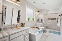Newly renovated Primary bathroom w/new tile floor, new shower tiled to ceiling w/frameless slider door, new mirrors and lighting.  XL freestanding tub.