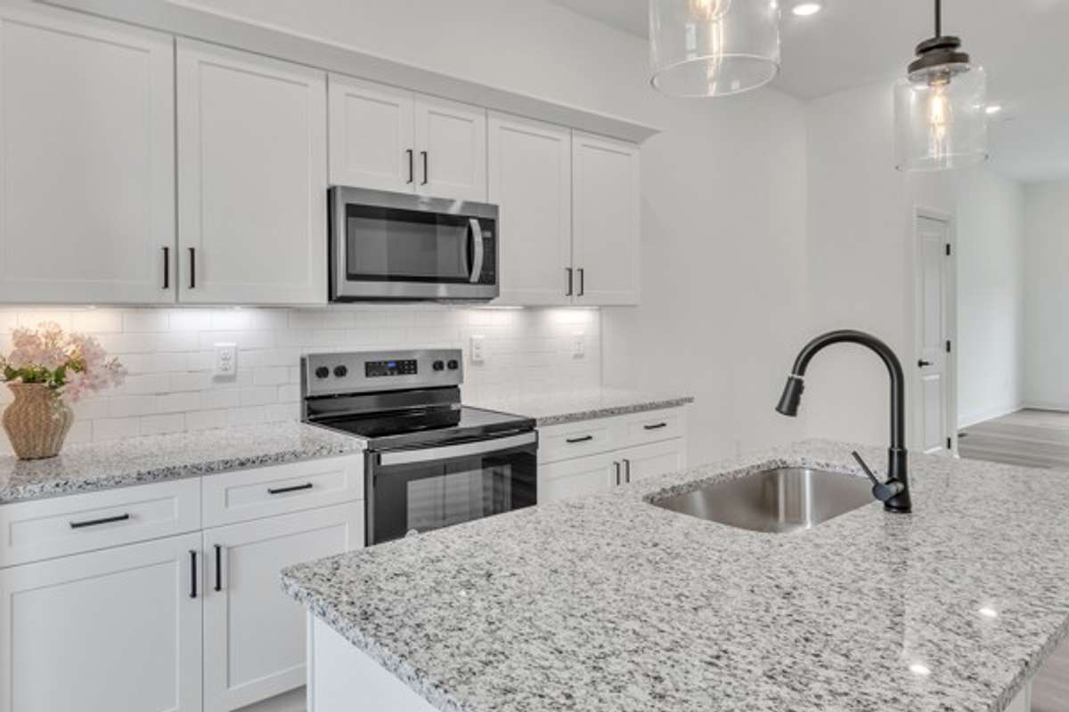 Be sure to take an extra look at the lovely granite, subway tile back splash & modern cabinetry.
