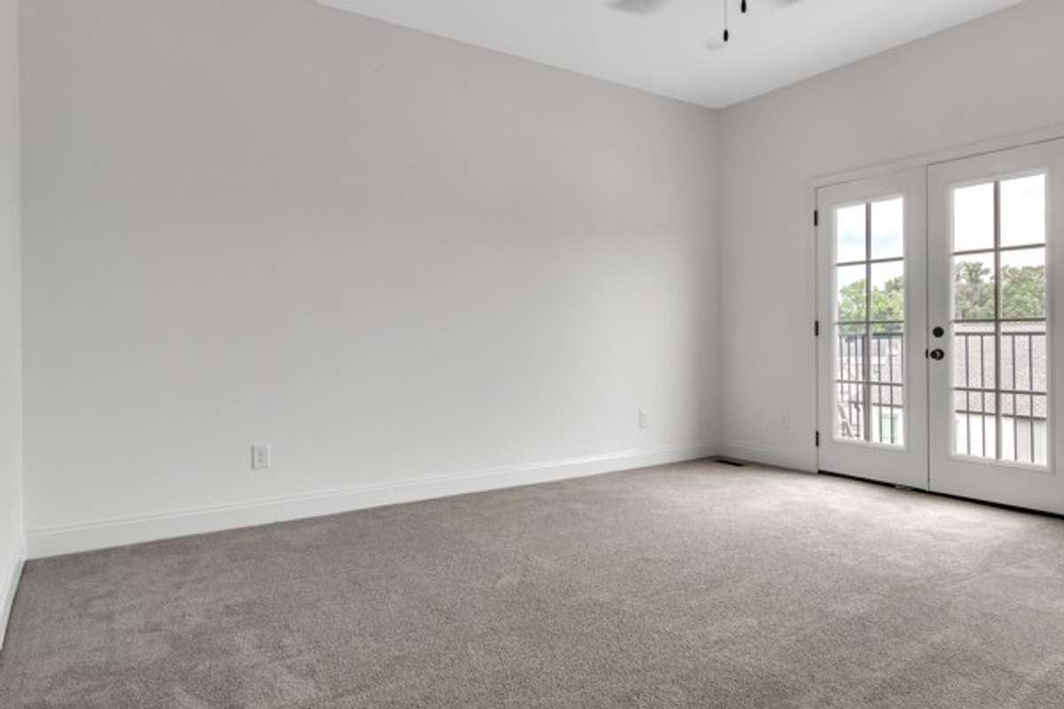 Spacious primary bedroom with 10 ft ceiling featuring more french doors and another adorable balcony for the owner's enjoyment.