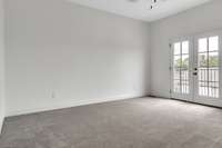 Spacious primary bedroom with 10 ft ceiling featuring more french doors and another adorable balcony for the owner's enjoyment.