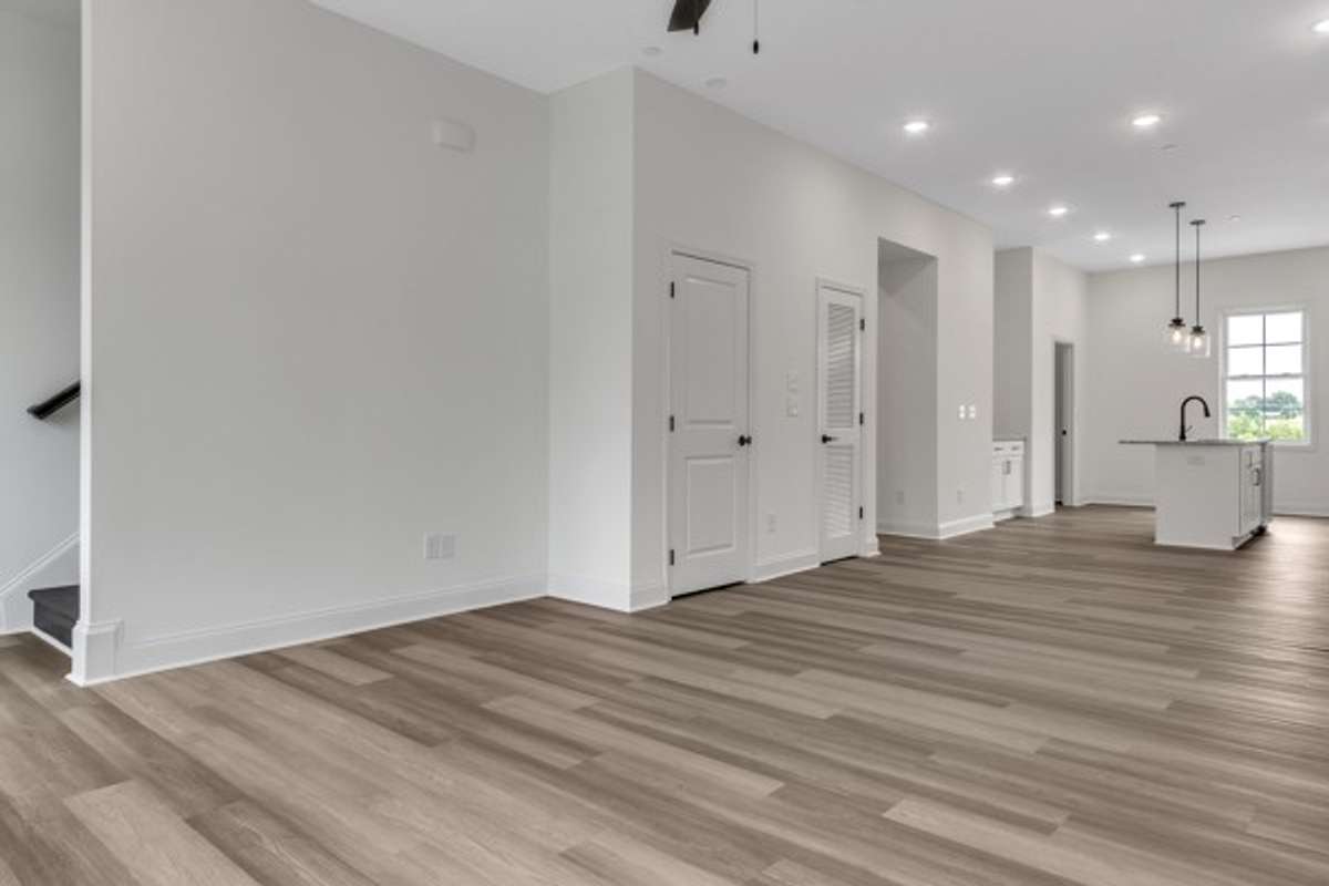 You will love the plentiful lighting and modern ceiling fans. This shot is back toward the dining and kitchen space. The stairs head up to the final 2 bedrooms including the primary bedroom and 2nd guest bedroom.