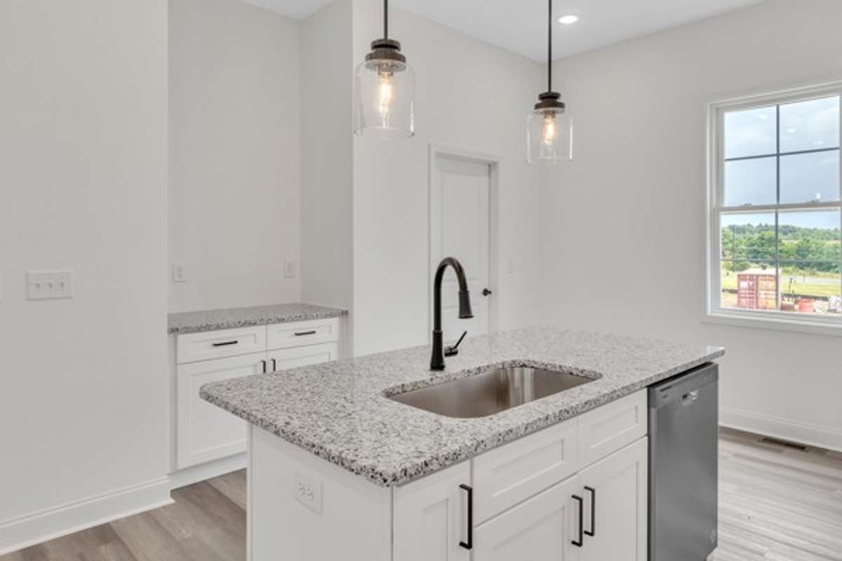 Notice the additional serving area across from large kitchen island and the door leads to a convenient pantry for additional storage.