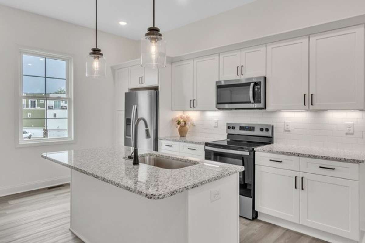 This kitchen is so bright and friendly with multiple light sources including the pendants, recessed lighting, under cabinet lighting and large window to let natural light stream in.