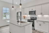 This kitchen is so bright and friendly with multiple light sources including the pendants, recessed lighting, under cabinet lighting and large window to let natural light stream in.