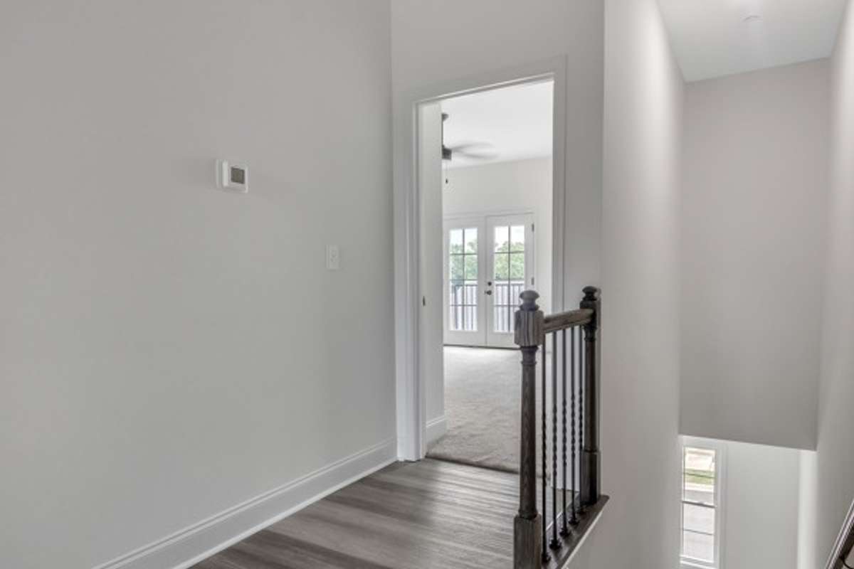 Entry to primary bedroom to the right of stairs on front side of home.