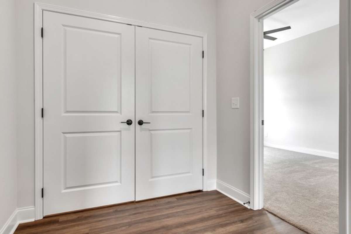 3rd floor landing with laundry room entry to 2nd guest bedroom.