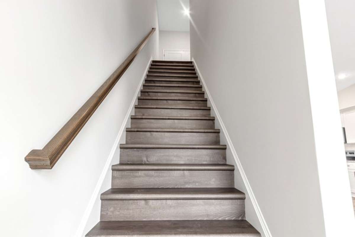 Stained hard wood stairway to the 3rd floor to the owner’s retreat, laundry room and 2nd guest room.