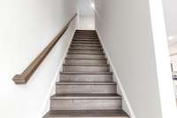 Stained hard wood stairway to the 3rd floor to the owner’s retreat, laundry room and 2nd guest room.