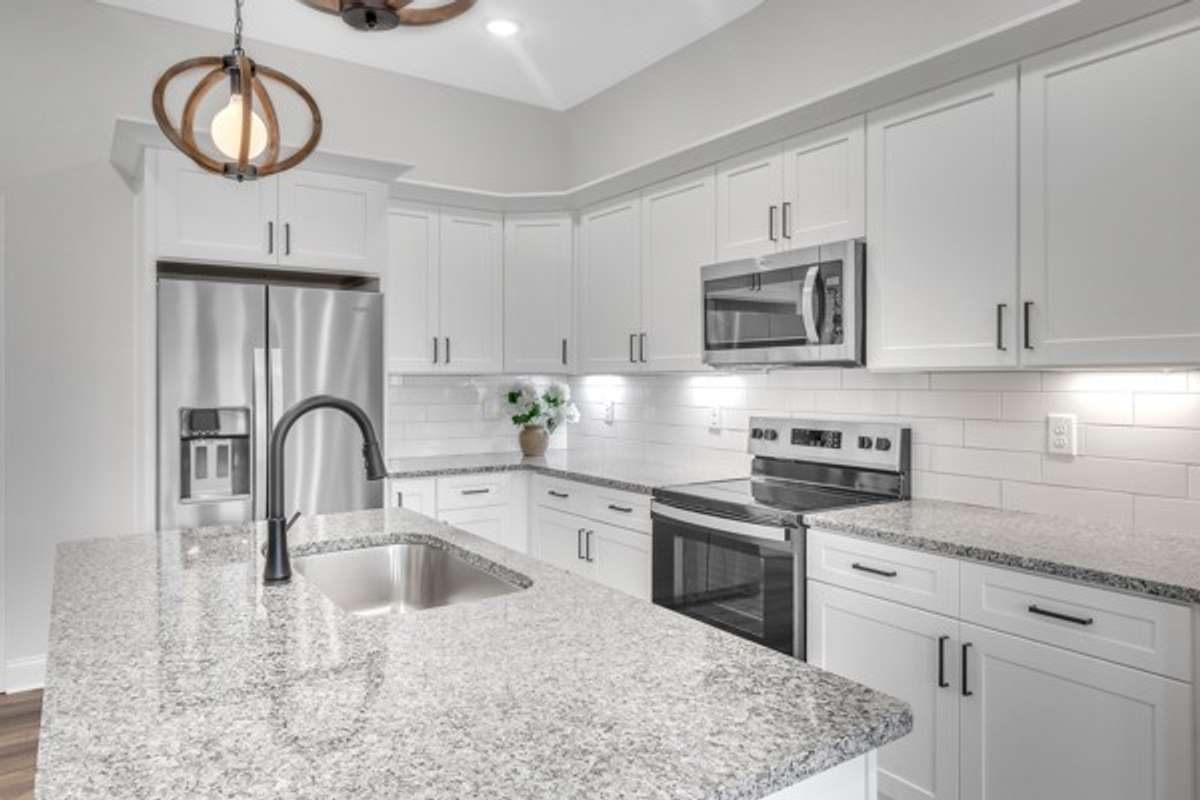 This kitchen is stunning with a large island, granite counter tops, tile back splash and under cabinet lighting.