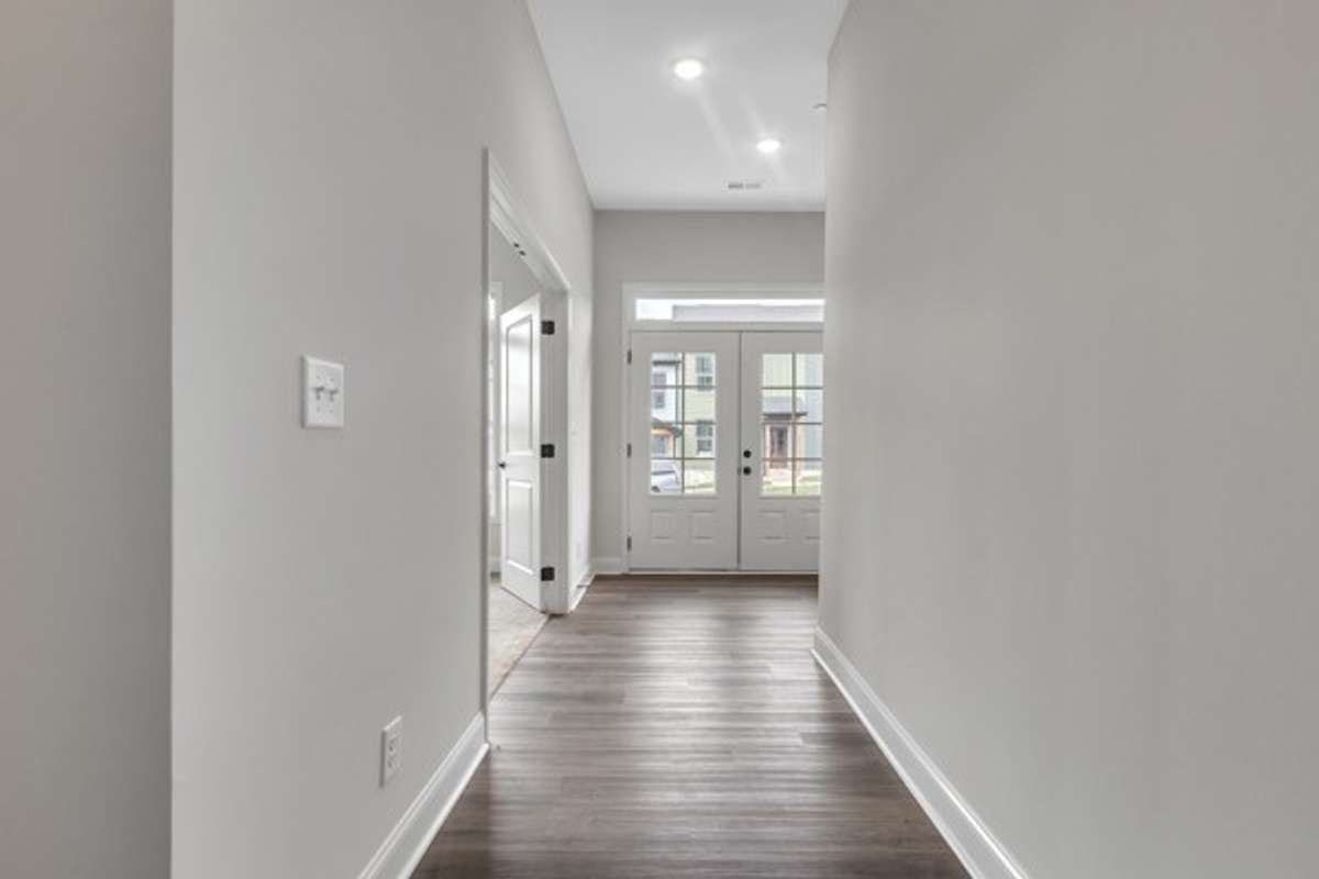 A great look toward the bright entry foyer to see the modern front doors and transom window above!
