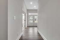 A great look toward the bright entry foyer to see the modern front doors and transom window above!
