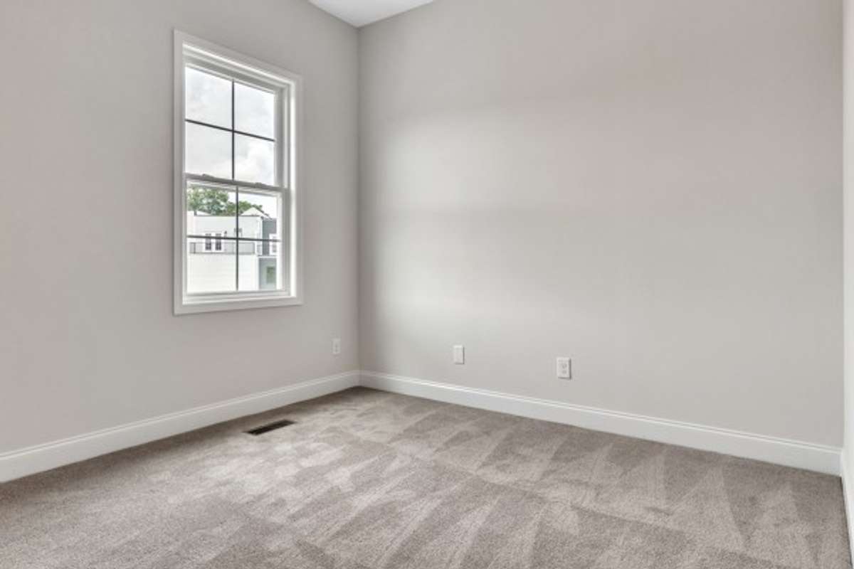 Guest bedroom just off the kitchen area with 10 ft ceiling, trendy ceiling fan and lighting.