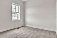 Guest bedroom just off the kitchen area with 10 ft ceiling, trendy ceiling fan and lighting.