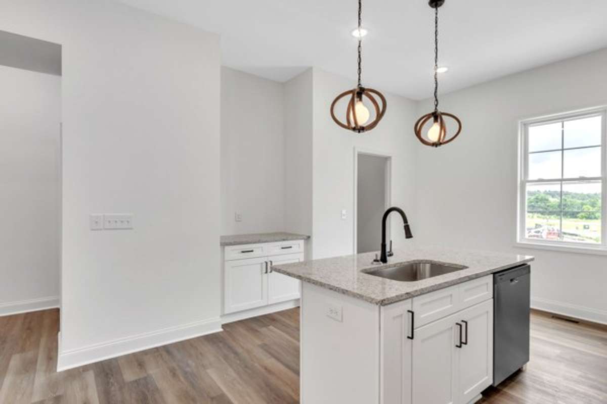 Notice the additional serving area across from large kitchen island and the door leads to a convenient pantry for additional storage.