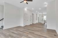 You will love the plentiful lighting and modern ceiling fans. This shot is back toward the dining and kitchen space. The stairs head up to the final 2 bedrooms including the primary bedroom and 2nd guest bedroom.