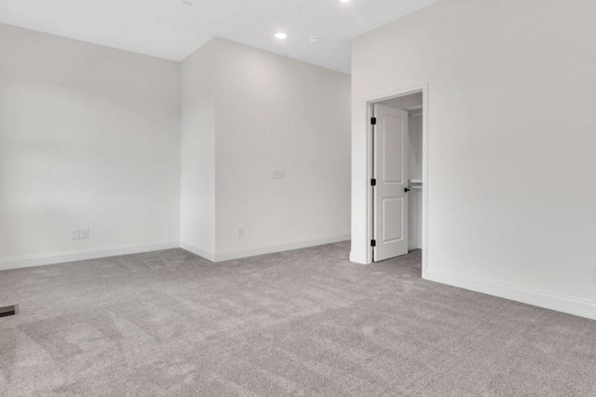 Another angle of the expansive primary bedroom and the entry to owner's closet.