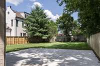 A private outdoor retreat featuring a spacious cement pad—ideal for a basketball hoop, or extra parking—surrounded by lush greenery for a serene, natural backdrop.