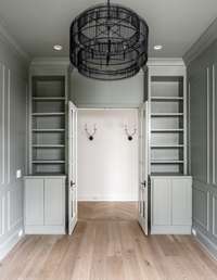 A fresh perspective on the study reveals custom built-in bookshelves—perfect for displaying your favorite reads or collected treasures—all framed by refined trim and soft, moody tones.