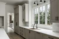 The three windows above the sink flood the kitchen with natural light and provide a picturesque view while rinsing dishes.