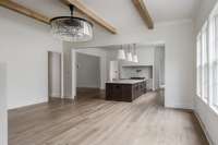 Thoughtfully designed open-concept living room featuring European white oak hardwoods, built-in speakers, and recessed lighting throughout—all anchored by a striking chandelier and seamless flow into the chef’s kitchen.