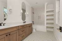 Upstairs primary bathroom is designed for both style and function, and features dual vanities with quartz countertops, a shower/tub combo, and eye-catching floor tile that adds a touch of personality to the space.