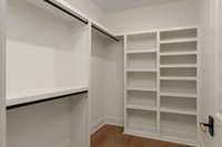 This spacious walk-in closet is outfitted with custom built-in systems—offering smart storage solutions and a streamlined sense of organization.