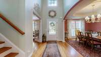 Looking back at the front entrance of the home impresses with soaring 18-foot ceilings, creating a grand and airy first impression.