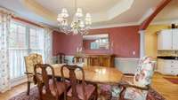 Open formal dining room features trey ceilings and stately columns, exuding timeless sophistication and architectural charm.