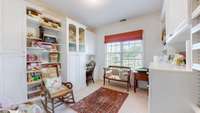 Third bedroom on upper level is currently being used as a hobby room with surrounding built-in cabinets and workspaces.