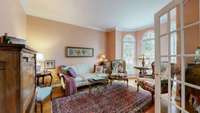 Front office with french door opening and arched windows currently being used as a sitting room.
