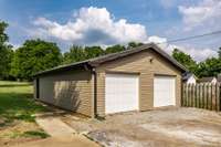 Detached garage with two garage door openers and new siding on garage