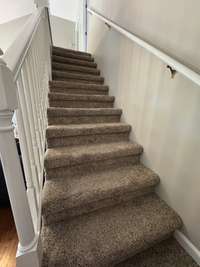 Staircase to 2 of the bedrooms and a full bath on the second level