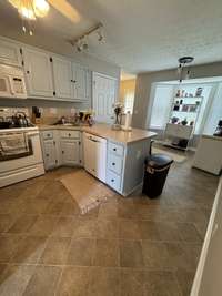Kitchen with smooth top stove, built-in microwave, penisula island and disposal.