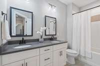 The upstairs bathroom features dual vanities and a shower/tub combo.