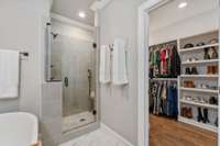 The primary closet features built in shelving to provide plenty of storage space