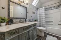 Full Bath located in the hall with a beautiful vanity that access both bedrooms