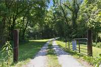 Drive through the gate to acres of beautiful farm land, shimmering lakefront, and the charm of country living.