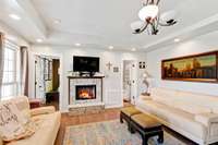 Living room offers granite gas fireplace, trey ceiling, and recessed lighting.