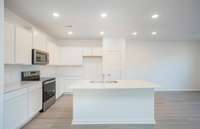 ***Photo from another townhouse recently completed in community with same finishes***  The Kitchen will feature white cabinetry, quartz countertops, white subway tile backsplash and stainless steel appliances.