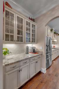 Butlers Pantry connects the Formal Dining and Kitchen and features glass doors for your displays and a large walk in Pantry.  The Butlers Pantry also features under cabinet lighting and granite counters.