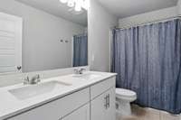 The upstairs bathroom features a shower/tub combo and dual vanities