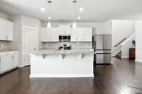 Spacious granite-topped kitchen island with seating for four- perfect for casual meals or gathering with family and friends.