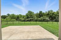 Sip your morning coffee or unwind at sunset while taking in the serene backyard view of greenery and trees from the covered patio.