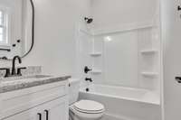 Private bath for 2nd guest bedroom with 10 ft ceilings, granite & modern decor and fixtures all highlighted by a window for natural lighting.