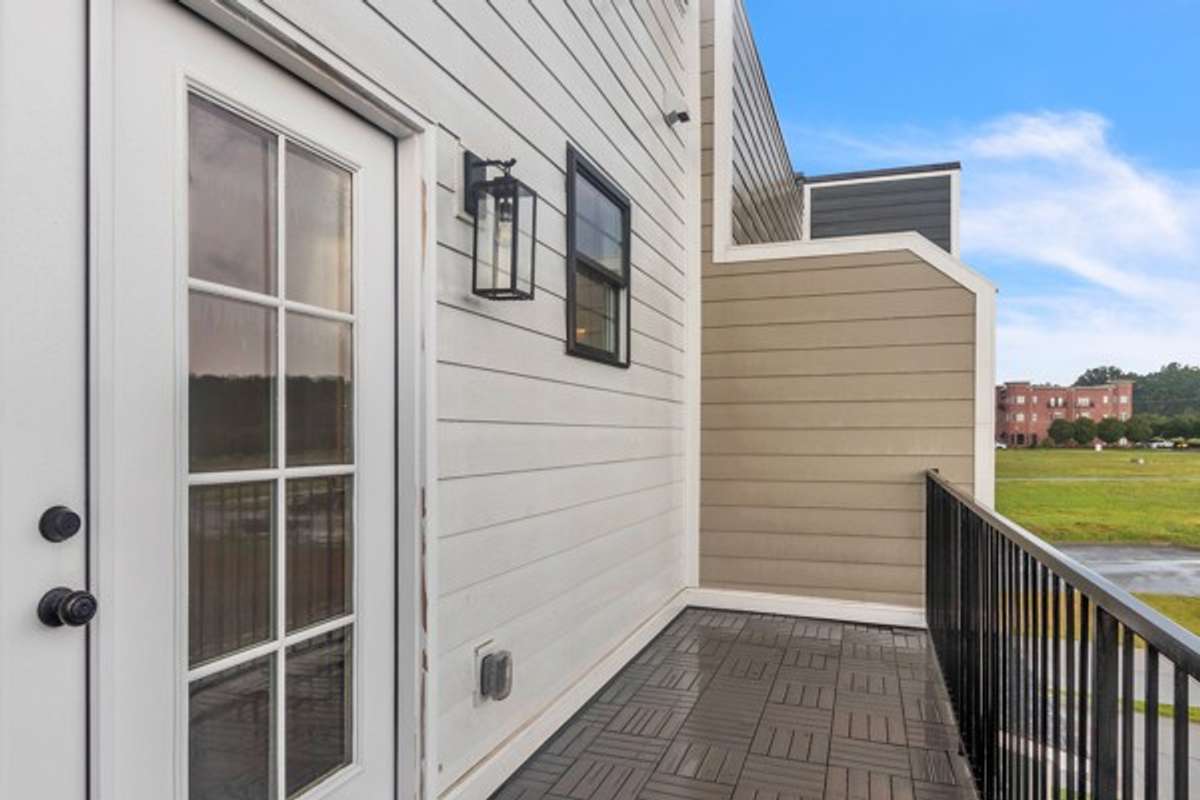 French doors lead to a large private deck for guests and family to enjoy. Notice the additional window to add more natural light to the guest bath.