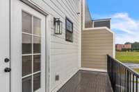 French doors lead to a large private deck for guests and family to enjoy. Notice the additional window to add more natural light to the guest bath.